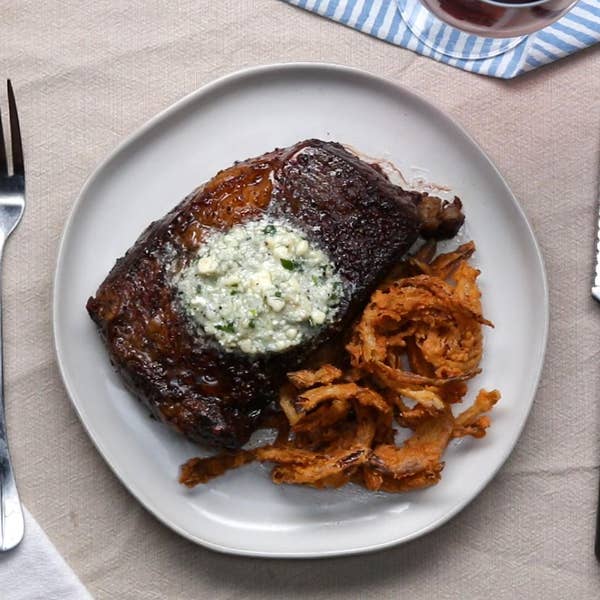 Rib Eye Steak With Blue Cheese Compound Butter And Crispy Onion Strings