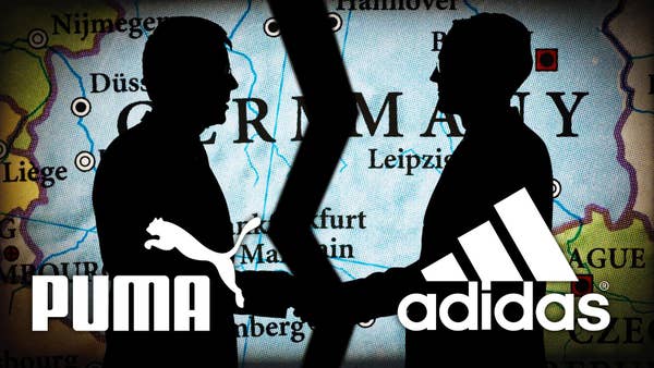 The logos of Puma and Adidas are over an image of black silhouettes of two men shaking hands with a map projection behind them of Germany being torn in half.  