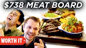 史蒂文和安德鲁在一张巨大的肉板旁边笑了起来，上面有很多肉和配菜。