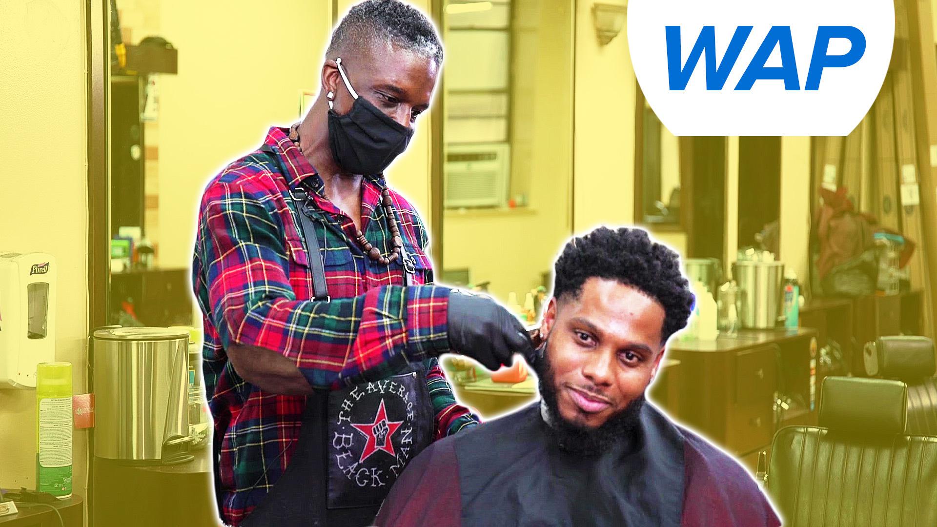 A barber cuts a client's hair