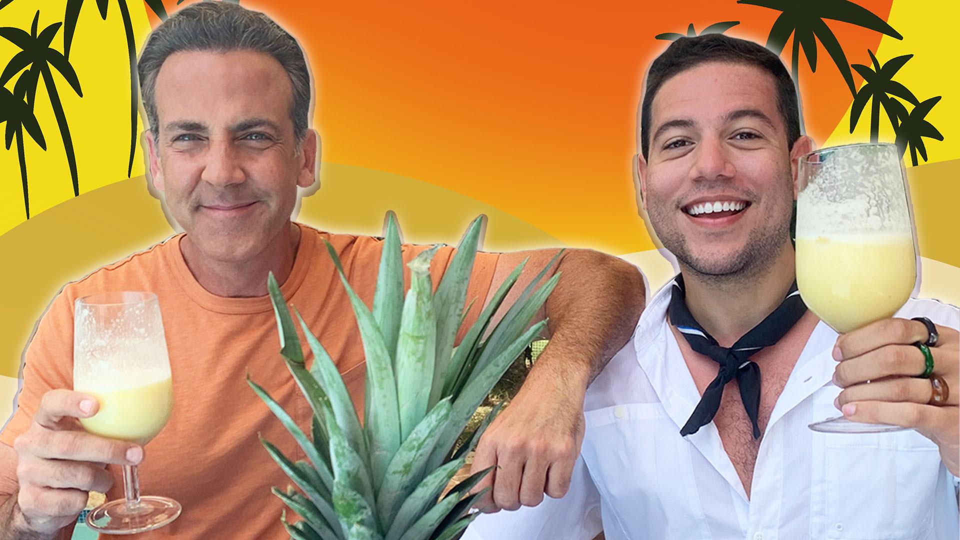 Carlos and Iván holding their piña coladas up for the camera with a tropical background
