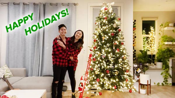 jasmine and george hugging in front of christmas tree, text reads happy holidays