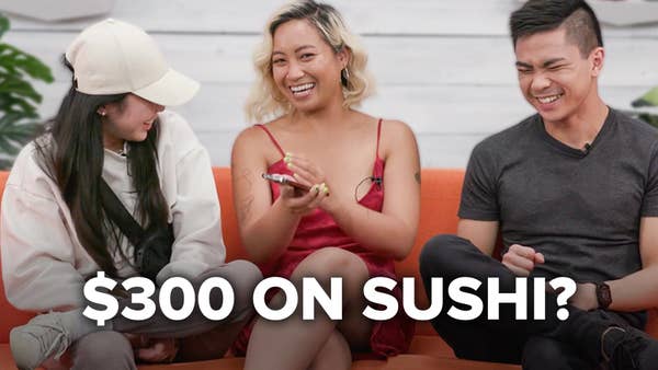 The bachelorette smiles in a red dress with her girlfriend in a ballcap looking at her grinning and the host, Chris Jereza, laughing. The text in front of them reads "$300 ON SUSHI?"
