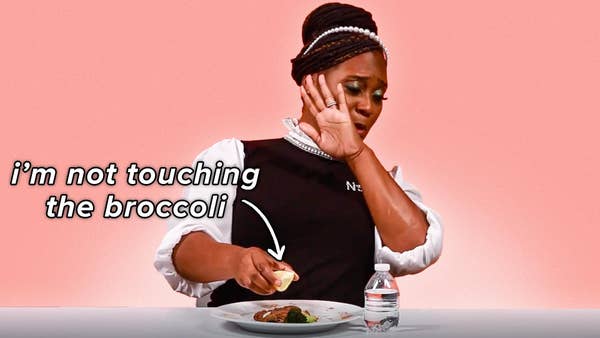 A woman covers her mouth and looks away from the food as she drops it back on the plate. A text bubble, reading "i'm not touching the broccoli" hovers over the plate.