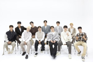 Seventeen K-Pop  group posed on a chair.