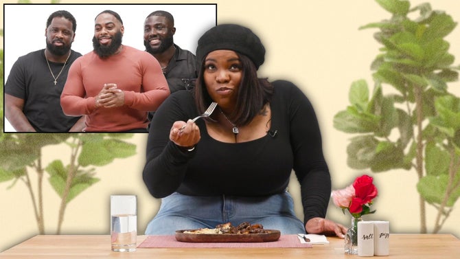 Jionne sits at a table between two fake planter trees chewing a forkful of stew. The stew sits before her on a wooden plate next to a vase of pink flowers.