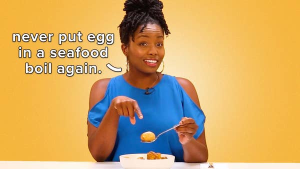 Woman in blue shirt smiles while pointing to a boiled egg on her spoon. Text reads, "Never put egg in a seafood boil again."